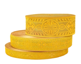 Puede incluir: Tres rollos de ribete amarillo con un intrincado patrón floral. El ribete está hecho de una tela tejida y tiene una textura ligeramente en relieve.