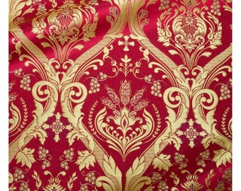 Puede incluir: Tela roja con un patrón de damasco dorado. El diseño presenta vides onduladas, elementos florales y motivos similares al trigo. La tela tiene una apariencia brillante y texturizada, adecuada para tapicería o proyectos decorativos.