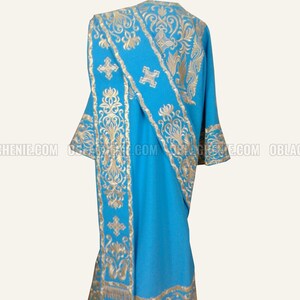 May include: A blue liturgical vestment with gold embroidery. The vestment has a cross and floral patterns.