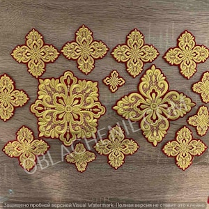 May include: A set of 13 gold and red embroidered cross patches. The crosses are of various sizes and feature intricate designs.