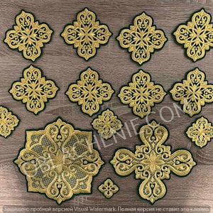 May include: A set of 14 gold embroidered patches with intricate designs. The patches are on a brown wooden surface. The patches are all different sizes and shapes, but they all have a similar design. The patches are perfect for adding a touch of elegance to any project.