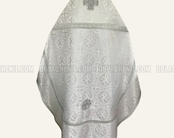 May include: White liturgical vestment with silver embroidery of crosses and Greek letters. The vestment has a decorative border and a large cross at the top.