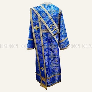 May include: A blue liturgical vestment with gold and silver embroidery. The vestment features a cross pattern and the word "Cта" in gold lettering.