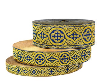 Puede incluir: Tres rollos de ribete dorado y azul con un diseño de cruz. El ribete está tejido con un patrón repetido de cruces y formas geométricas.