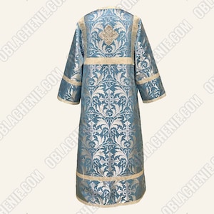 May include: A light blue liturgical vestment with a silver and white floral pattern. The vestment has a gold trim and a cross design.