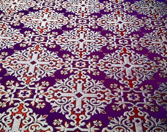 May include: Purple fabric with a silver and red repeating pattern of a cross surrounded by ornate floral designs.