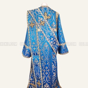 May include: A blue liturgical vestment with gold embroidery and crosses. The vestment has a decorative pattern of floral designs and crosses.