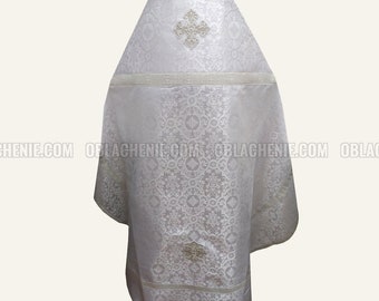 Könnte beinhalten: Weißes liturgisches Gewand mit Kreuzmuster und kompliziertem Blumenmuster. Das Gewand hat eine Kapuze und ist aus Brokatstoff gefertigt.
