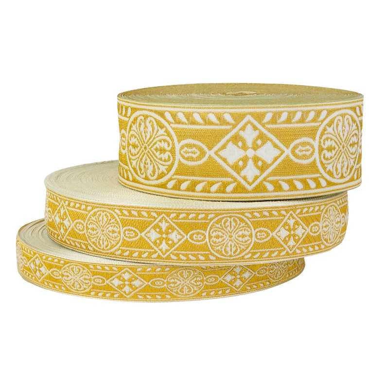 May include: Three rolls of gold trim with a white floral pattern. The trim is woven with a repeating design of flowers and diamonds.