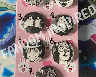 May include: Seven black and white anime-inspired button pins with numbers 1 through 7. The pins are on a pink background with white bunny and strawberry designs.
