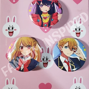 May include: Three round anime character buttons. The first button features a girl with long black hair wearing a red and yellow outfit with stars. The second button features a girl with long blonde hair wearing a black and red school uniform. The third button features a boy with blonde hair wearing a black and blue school uniform.