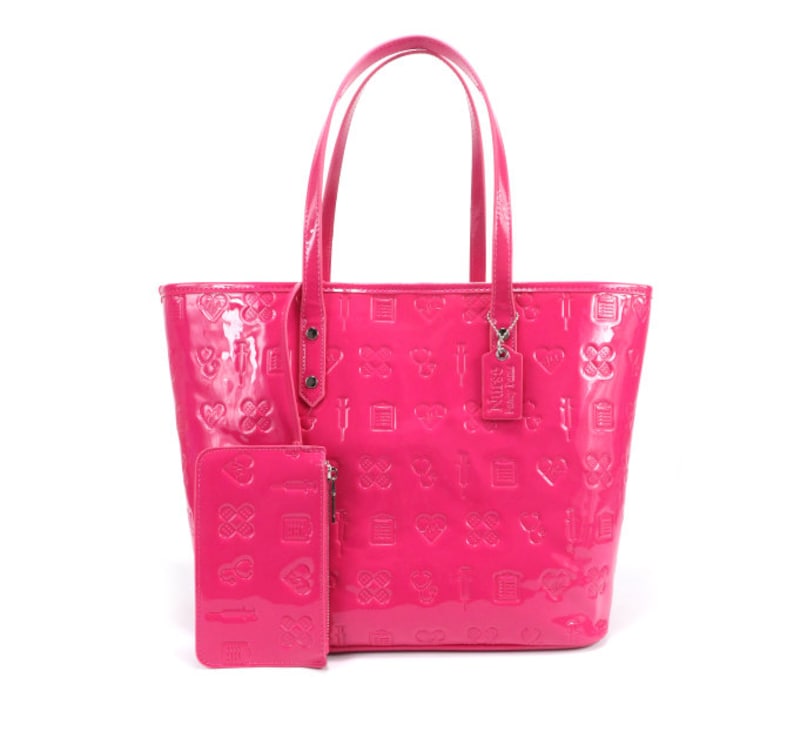 Puede incluir: Un bolso tote rosa brillante con una bolsa con cremallera rosa a juego. El bolso tiene un patr&oacute;n de corazones, cruces y otros s&iacute;mbolos en relieve en el cuero. El bolso tiene dos asas superiores y un dije desmontable con el texto "Nurse Life" en &eacute;l.