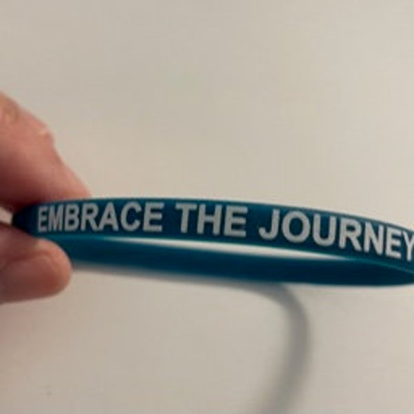 Embrace the Journey stretchy durable silicone wristband measures 1/4" x 8". Buyers have options to add 2 thin or 1 wide band