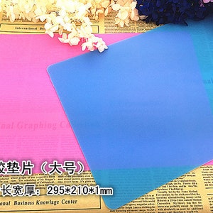 May include: Two silicone craft mats, one pink and one blue, with the text "硅胶垫片(大号)" and "尺寸长宽厚: 295*210*1mm" printed on the pink mat.