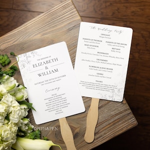 Puede incluir: Abanicos de programa de ceremonia de boda con un diseño floral y el texto "The Wedding of Elizabeth & William" y "Saturday the Fifth of October, Two Thousand and Twenty". Los abanicos están sobre una superficie de madera.