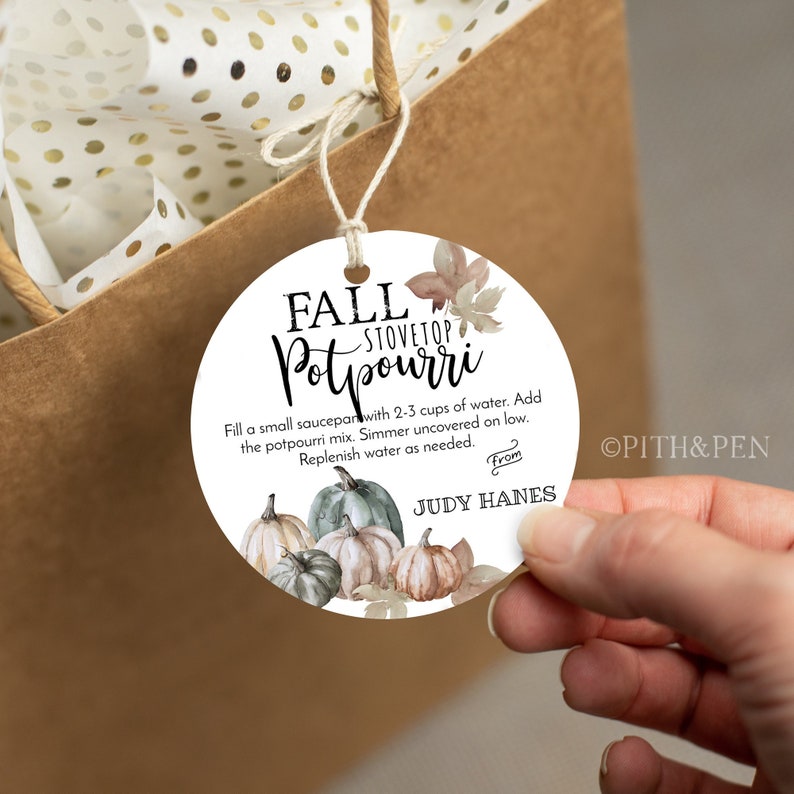May include: A white round gift tag with a watercolor illustration of pumpkins and fall leaves. The text on the tag reads "Fall Stovetop Potpourri" and includes instructions for using the potpourri. The tag also includes the text "From Judy Hanes".