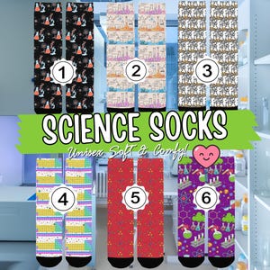 May include: A collection of six pairs of science-themed socks. The socks feature various patterns including beakers, molecules, and lab equipment in colors like black, red, purple, and yellow. The text "SCIENCE SOCKS" is displayed in a green banner.