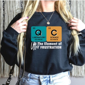 May include: Black sweatshirt with a graphic of two periodic table elements, Q and C, with the text "The Element of Utter Frustration".
