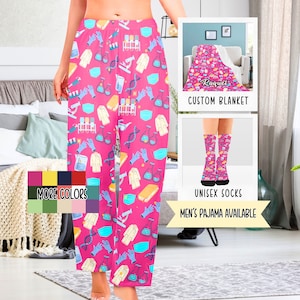 May include: Pink pajama pants with a science theme. The pattern includes beakers, test tubes, lab coats, DNA strands, and face masks. The pants are available in multiple colors. The image also shows a matching blanket and socks.