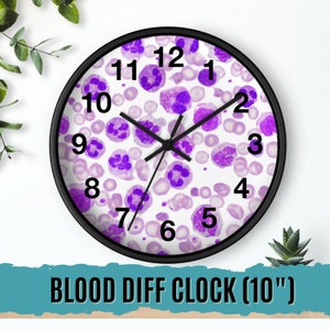 May include: A 10-inch clock with a black frame and white face. The face is covered in a pattern of purple and white blood cells. The numbers 1 through 12 are printed in black around the edge of the clock face. The clock hands are black.