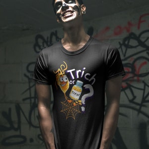 以下が含まれることがあります： ハロウィーンをテーマにしたグラフィックがプリントされた黒いTシャツ。デザインは、漫画風の笑顔の黄色い生き物、"Treat"と書かれたボトル、疑問符、そして白と紫で書かれた"Trick or Treat"という言葉が特徴です。