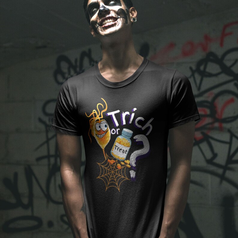以下が含まれることがあります： ハロウィーンをテーマにしたグラフィックがプリントされた黒いTシャツ。デザインは、漫画風の笑顔の黄色い生き物、"Treat"と書かれたボトル、疑問符、そして白と紫で書かれた"Trick or Treat"という言葉が特徴です。