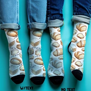 May include: White socks with a sourdough bread pattern. The socks have black heels and toes. The text "sourdough hoo" is printed on the socks. The socks are worn with blue jeans.