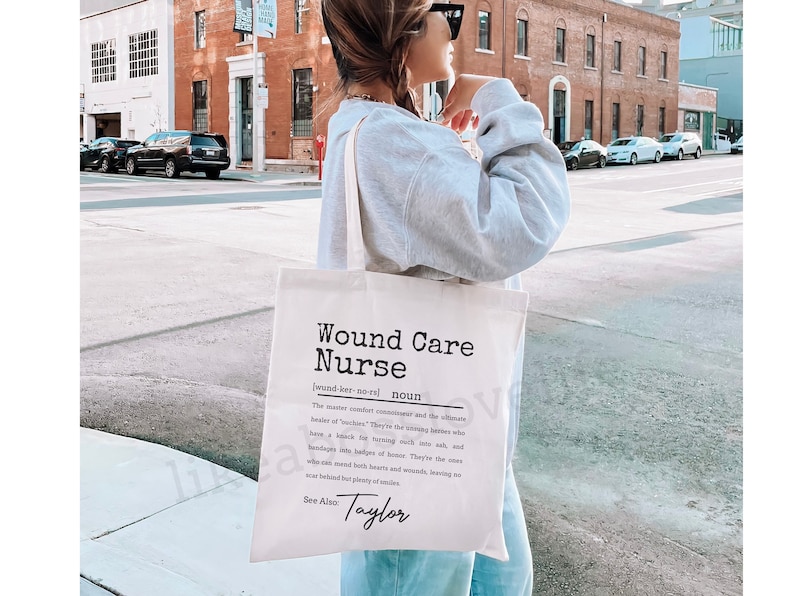 May include: A white tote bag with black text that reads "Wound Care Nurse" and a definition of the term. The bag also includes the name "Taylor" at the bottom.