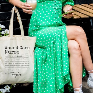May include: A white tote bag with a black and white definition of "Wound Care Nurse" printed on it. The definition includes the text "See Also: Taylor".