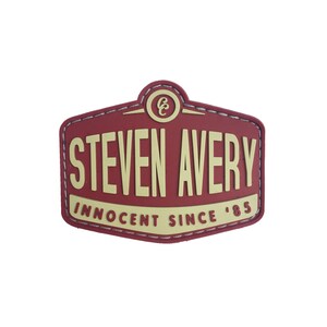 Peut inclure: Écusson brodé rouge et jaune avec le texte "STEVEN AVERY INNOCENT SINCE '85" et un petit cercle contenant la lettre "C".