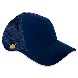 Puede incluir: Una gorra de camionero de malla azul marino con una corona dorada bordada en la parte delantera.