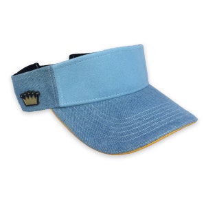 May include: A light blue denim visor with a yellow trim and a gold crown logo on the side.
