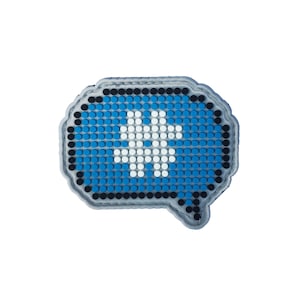 Puede incluir: Una burbuja de diálogo azul y blanca hecha de pequeñas cuentas redondas. La burbuja de diálogo tiene una silueta blanca de una persona en su interior.