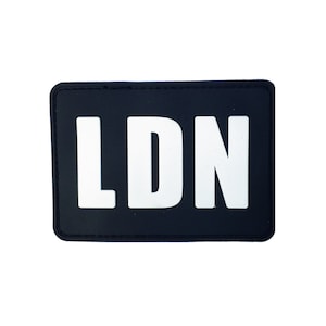 May include: Black patch with white letters spelling out "LDN"
