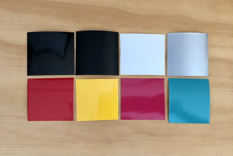 K&ouml;nnte beinhalten: Acht quadratische Muster aus verschiedenen Vinylfarben, darunter Schwarz, Wei&szlig;, Silber, Rot, Gelb, Pink und T&uuml;rkis.