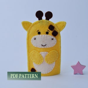 May include: A yellow felt finger puppet shaped like a giraffe with brown ears, brown spots, and a white face. The puppet has a stitched smile and X-shaped eyes. The text "PDF PATTERN" is visible at the bottom of the image.