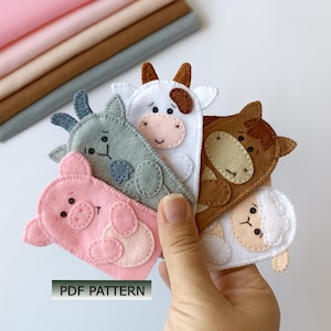 May include: A set of five felt animal finger puppets featuring a pink pig, a gray goat, a white cow, a brown horse, and a white sheep, each with stitched facial details. The text PDF PATTERN is visible in the lower left corner.