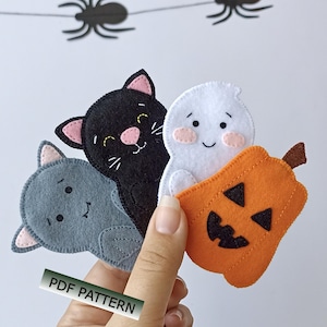 Peut inclure: Un ensemble de quatre décorations en feutrine pour Halloween représentant un chat gris, un chat noir, un fantôme blanc et une citrouille orange. Les articles portent le texte PDF PATTERN. Les figurines sont cousues et ont des visages simples.