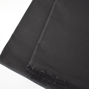 Peut inclure: Tissu Aida noir, un type de tissu utilis&eacute; pour la broderie au point de croix, avec une bordure en frange noire.