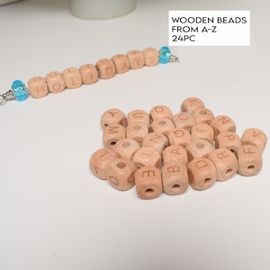 Può includere: Un set di 24 perline in legno a forma di lettere, ogni perlina è un cubo con una lettera dell'alfabeto incisa su di essa. Le perline sono di colore marrone chiaro e sono sparse su una superficie bianca. Le perline sono disposte in un mucchio, con alcune perline che si sovrappongono. Le perline sono tutte della stessa dimensione e forma. Le perline sono fatte di legno e sono lisce al tatto. Le perline sono perfette per l'uso in artigianato, creazione di gioielli e altri progetti creativi.