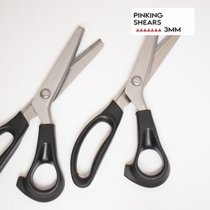 May include: Two pairs of black handled pinking shears with a 3mm blade. The shears are on a white background. Pinking shears are used to create a zig-zag edge on fabric.