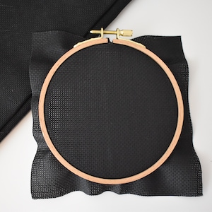 Peut inclure: Un cercle &agrave; broder noir avec un morceau de tissu Aida noir tendu dessus.