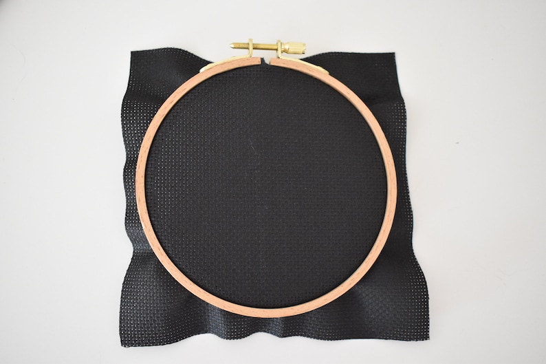 Peut inclure: Un cercle &agrave; broder noir avec un cadre en bois et un tissu Aida noir tendu dessus.