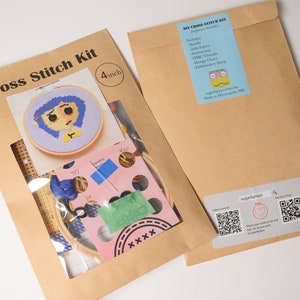 May include: A brown paper envelope with a clear plastic window showing a cross stitch kit. The kit includes a 4-inch embroidery hoop, Aida fabric, DMC threads, a needle, and a design chart. The design is a cartoon character with blue hair and a yellow shirt. The envelope also has a label with the text "DIY Cross Stitch Kit" and a QR code.
