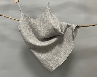 May include: Gray woven sleeveless top hanging on a wooden hanger. The top is made of a lightweight fabric with a subtle texture.