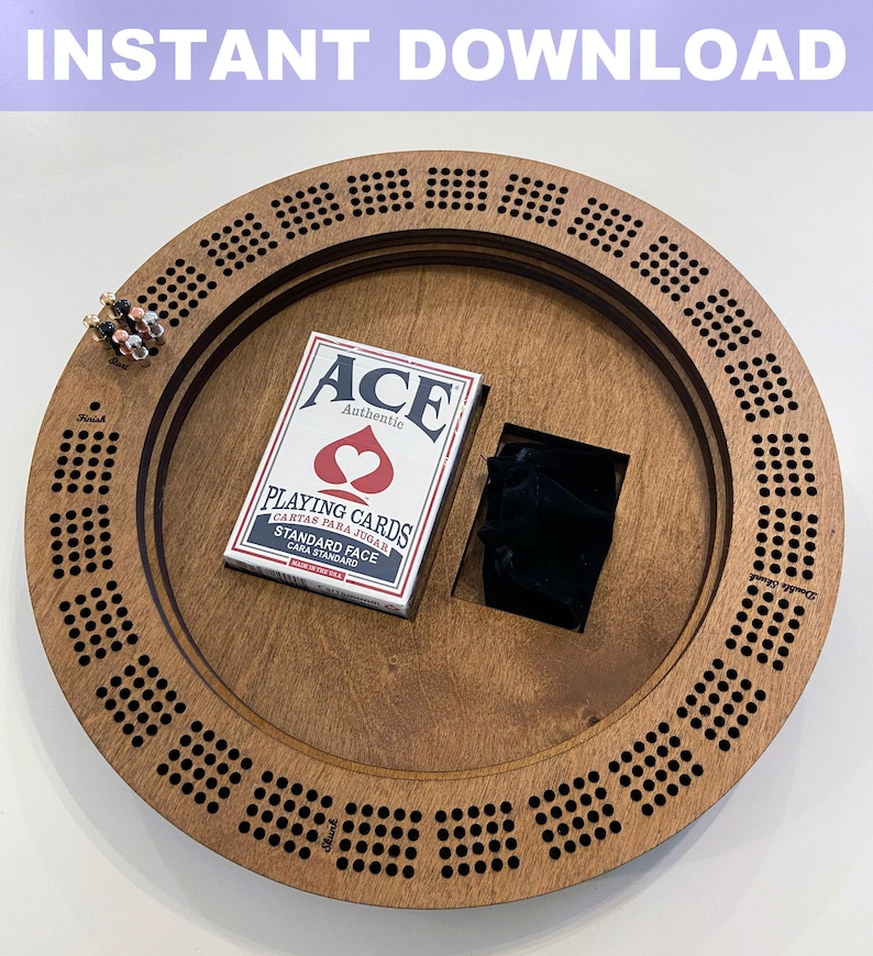 May include: A wooden cribbage board with a deck of playing cards and a small pouch. The board has a circular shape with a center hole and a ring of holes around the edge. The board is made of light brown wood and has a natural finish.