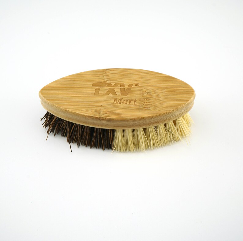 May include: An oval-shaped brush with brown and beige bristles and a bamboo handle. The handle has the text "TXV Mart" engraved on it.