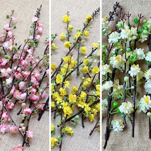 May include: Three floral arrangements showing branches with pink, yellow, and white flowers. The pink blooms have pink and white petals, the yellow flowers are small and clustered, and the white flowers have green accents.