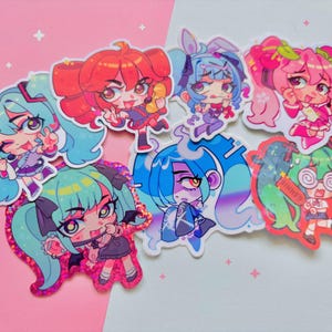 May include: A collection of colorful anime-style stickers featuring various characters with vibrant hair and outfits. The stickers have a holographic, glittery finish and are arranged on a pink and white background.