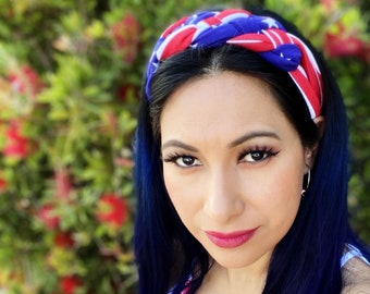 Könnte beinhalten: Eine Frau mit langen, dunkelblauen Haaren trägt ein rot-weiß-blaues Stirnband mit Sternen. Das Stirnband ist oben auf ihrem Kopf zu einem Knoten gebunden. Sie trägt ein rot-weiß-blaues Oberteil mit Muster.